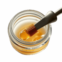 Vape oil being infused with a dropper in a glass jar, reflecting high-quality cannabis concentrate used in edibles and vaping products, aligning with Great Canadian Buds offerings.
