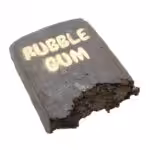 Close-up of a chocolate bar labeled "RUBBLE CAKE" with a textured, crumbly appearance and a bite taken out of one corner.