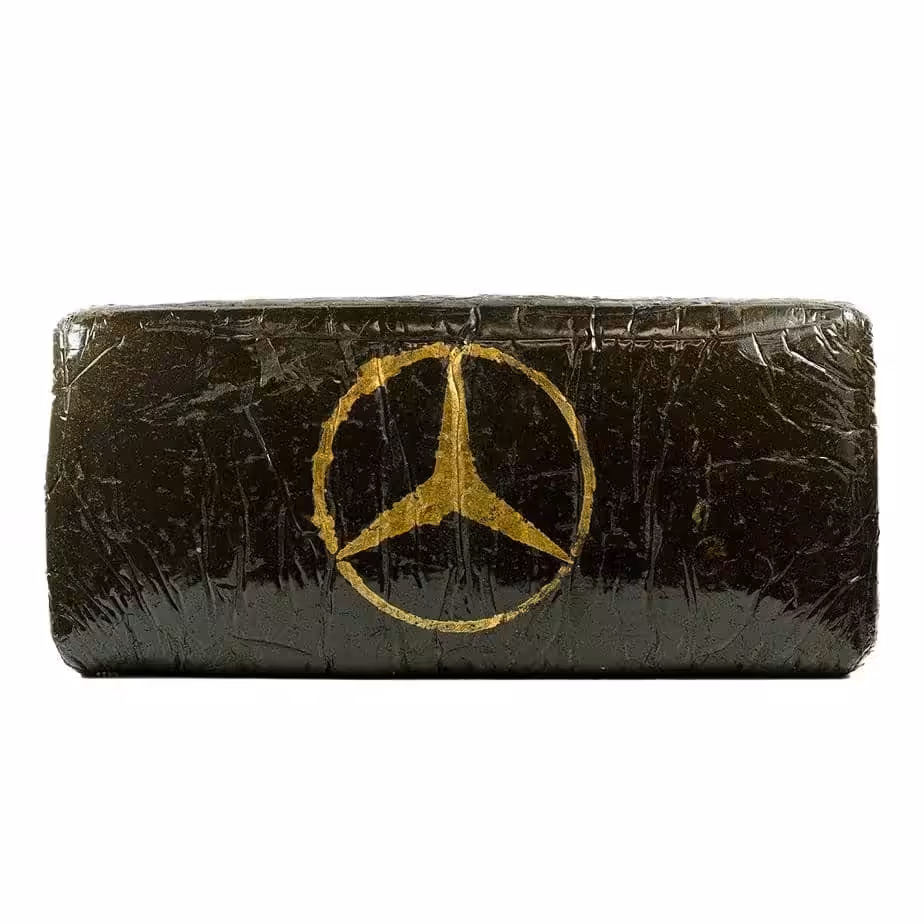 Luxury Cannabis Block with Mercedes-Benz Logo. High-quality cannabis packaging featuring a sleek black design and a gold Mercedes-Benz emblem, emphasizing premium cannabis products and luxury branding.