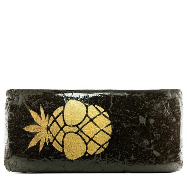High-quality cannabis block with sleek black wrapping and gold pineapple leaf and fruit design, perfect for legal recreational or medicinal cannabis users seeking premium marijuana products.