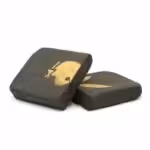 Detailed description: A close-up of black hash candies with a gold skull logo on top, showcasing premium cannabis-infused edibles from Great Canadian Buds, perfect for recreational or medicinal use.