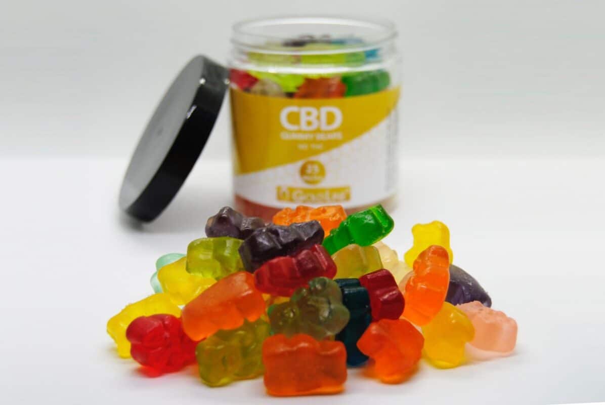 Vibrant CBD gummies in various colors and flavors, placed near a jar labeled "CBD" on a white surface. Perfect for natural health, stress relief, and medicinal use from Great Canadian Buds.