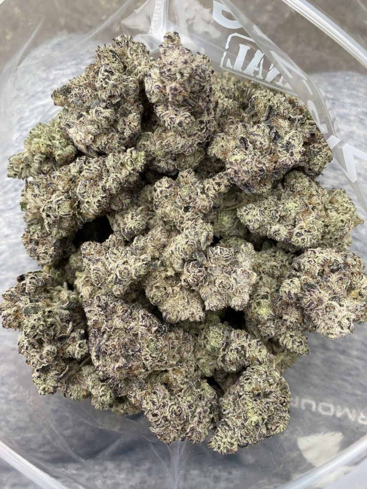 Frosty, high-quality cannabis buds with vibrant purple hues and dense trichomes for optimal potency. Perfect for connoisseurs seeking top-tier marijuana flower.