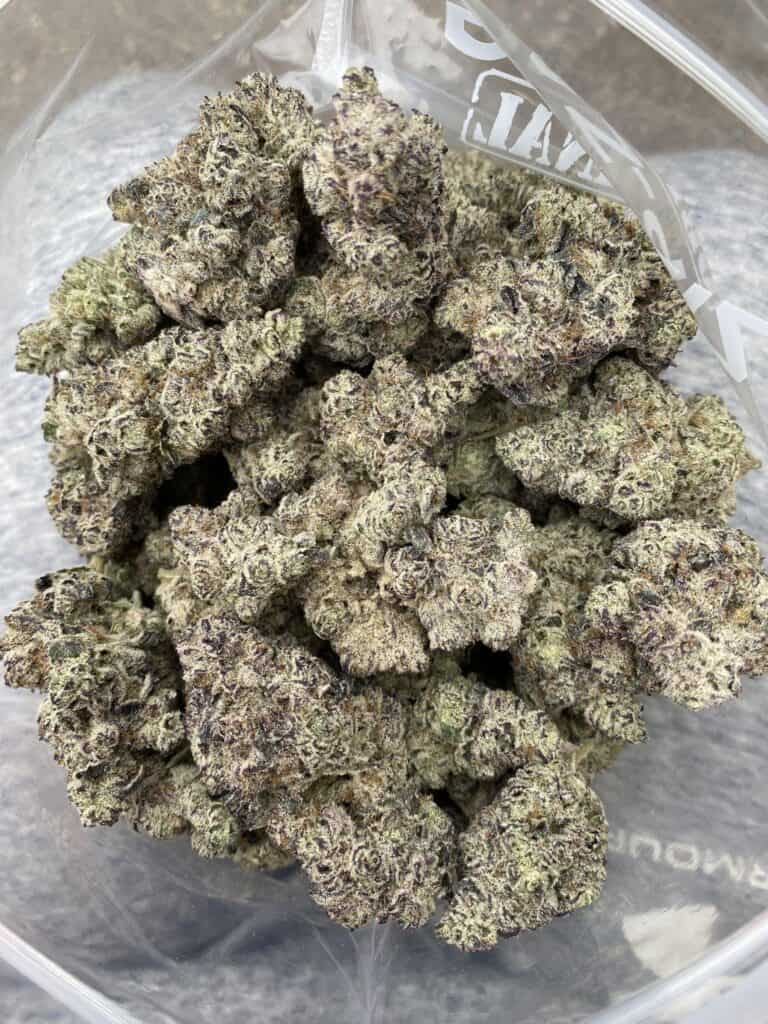 Frosty, high-quality cannabis buds with vibrant purple hues and dense trichomes for optimal potency. Perfect for connoisseurs seeking top-tier marijuana flower.