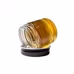 High-quality cannabis concentrate oil in a glass jar, featuring vibrant amber color, ideal for medicinal and recreational cannabis consumers seeking potent, pure THC or CBD extracts.