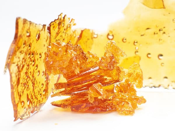 Golden cannabis shatter and concentrates with vibrant amber color, highlighting potency and purity from trusted Canadian dispensaries.