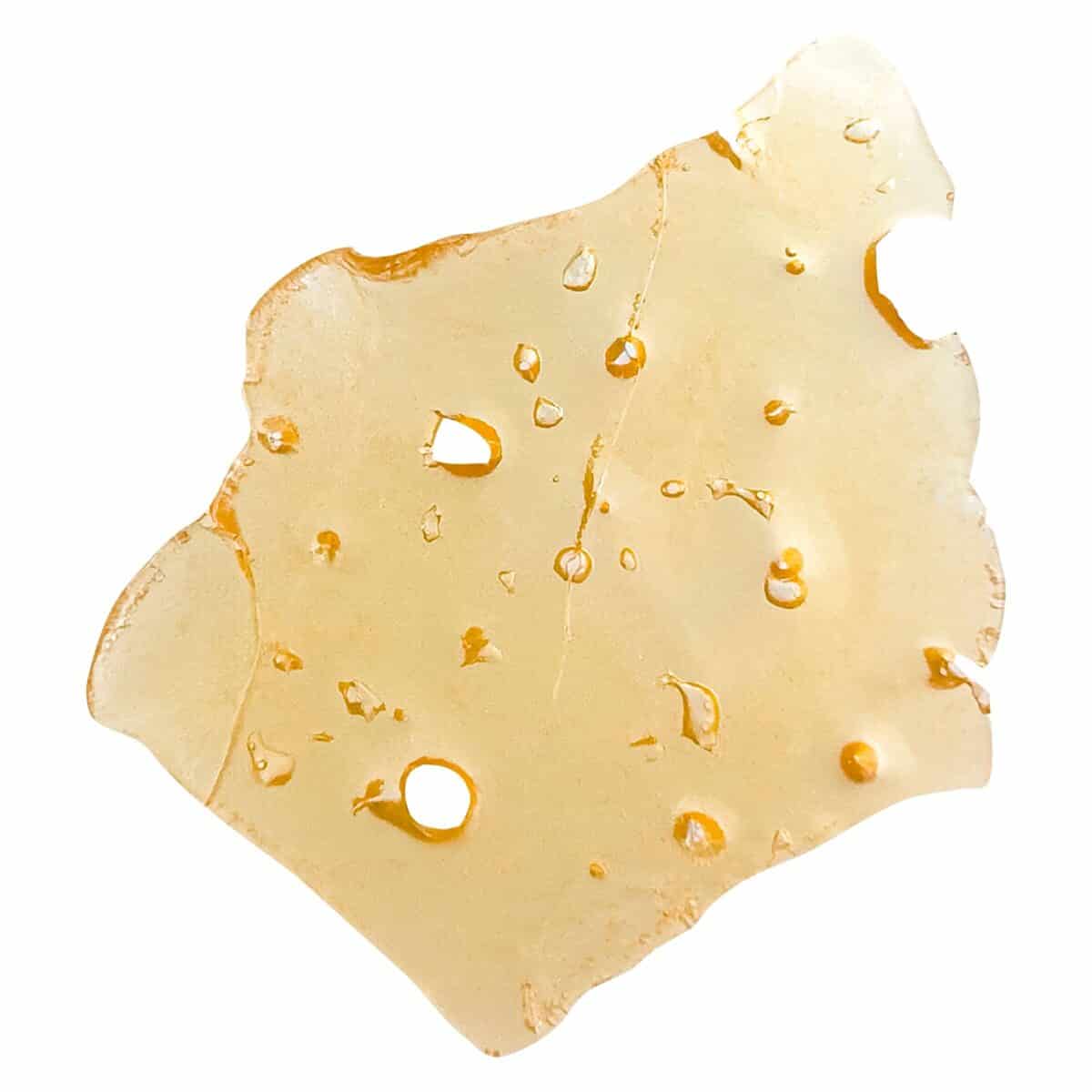 Close-up of a cannabis-infused edible slice with a yellowish hue, featuring small air bubbles and a smooth texture, ideal for cannabis enthusiasts and health-conscious consumers.
